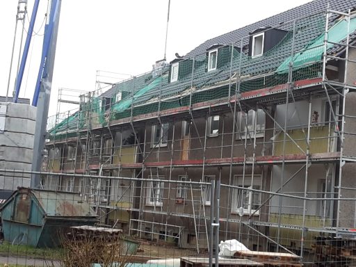 Baugerüst um ein mehrstöckiges Gebäude mit unvollendeter Fassade.