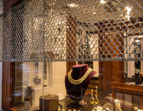 Schaufenster mit Schmuckstücken, darunter eine goldene Halskette und Ohrringe.